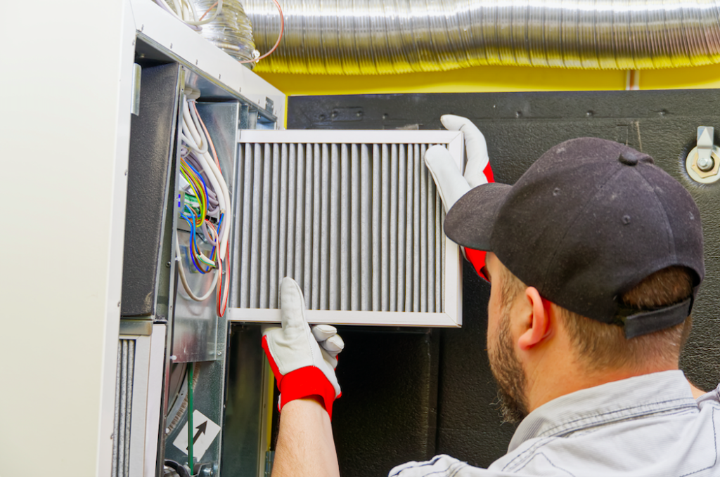 Professionnel qui procède au nettoyage des conduits de ventilation pour un immeuble résidentiel.